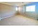 Neutral bedroom featuring baseboard trim, two windows, a built-in ledge, and carpeted floors at 2694 Rimpacific Cir, Las Vegas, NV 89146