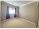 Beige bedroom with beige carpet, window, curtains, and a standing lamp at 2694 Rimpacific Cir, Las Vegas, NV 89146