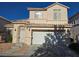 Two-story home featuring a two-car garage, desert landscaping, and a secured front entry gate at 2694 Rimpacific Cir, Las Vegas, NV 89146