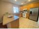 Bright kitchen featuring tile flooring, stainless steel appliances, and a view into the dining room at 2694 Rimpacific Cir, Las Vegas, NV 89146