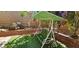 A backyard with a swing, brick planter, artificial grass and lush plants at 3131 Binaggio Ct, Las Vegas, NV 89141