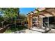 Inviting backyard featuring a pergola, swing, lush greenery, and BBQ grill, creating a perfect outdoor entertainment space at 3131 Binaggio Ct, Las Vegas, NV 89141