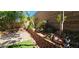 Landscaped backyard featuring a brick wall with planters, roses and art decorations at 3131 Binaggio Ct, Las Vegas, NV 89141