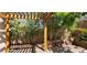 Backyard with a wooden pergola, lush greenery, and stone landscaping, offering a tranquil and private outdoor retreat at 3131 Binaggio Ct, Las Vegas, NV 89141