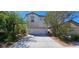 Inviting two-story home with a two-car garage, desert landscaping, and a bright blue sky at 3131 Binaggio Ct, Las Vegas, NV 89141