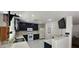 A kitchen with white tile floors, dark cabinets, white appliances, and a tv mounted on the wall at 3131 Binaggio Ct, Las Vegas, NV 89141