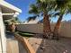 Landscaped backyard with palm trees and an artificial lawn at 3136 Jane Austin Ave, North Las Vegas, NV 89031