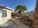 Side yard of the house featuring artificial grass, plants and block wall at 3136 Jane Austin Ave, North Las Vegas, NV 89031