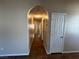 Hallway with hardwood floors and arched entryway, offering a view of the interior at 3136 Jane Austin Ave, North Las Vegas, NV 89031