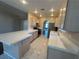 Well-lit kitchen with tile flooring, tile countertops, and stainless steel refrigerator at 3136 Jane Austin Ave, North Las Vegas, NV 89031