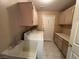 Functional laundry room with washer, dryer, sink, cabinets, and tile flooring at 3136 Jane Austin Ave, North Las Vegas, NV 89031