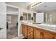 Bathroom with double sinks, wood cabinets, tile flooring, and a shower and tub at 3232 Brayton Mist Dr, North Las Vegas, NV 89081