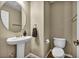 Powder room featuring a modern pedestal sink, toilet, and wood look flooring at 3232 Brayton Mist Dr, North Las Vegas, NV 89081