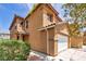 Side view of a two-story home with an attached two-car garage and desert landscaping at 3232 Brayton Mist Dr, North Las Vegas, NV 89081