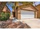 Side view of a two-story home with an attached two-car garage and desert landscaping at 3232 Brayton Mist Dr, North Las Vegas, NV 89081