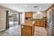 Spacious kitchen features wood cabinets, granite counters, stainless steel appliances, and access to a patio at 3232 Brayton Mist Dr, North Las Vegas, NV 89081