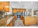 Stylish kitchen features wooden cabinets, granite countertops, stainless steel appliances and wood-look tile flooring at 3232 Brayton Mist Dr, North Las Vegas, NV 89081