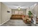 Living room with comfortable brown couch, ceiling fan, stairway, and wood look flooring at 3232 Brayton Mist Dr, North Las Vegas, NV 89081