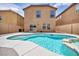 A backyard view of the refreshing pool with a spa and a two-story home in the background at 3232 Brayton Mist Dr, North Las Vegas, NV 89081