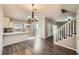 Open-concept living space with wood floors, modern lighting, and a staircase at 3253 Mystic Ridge Ct, Las Vegas, NV 89129