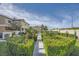 Landscaped walkway leading to a community with lush greenery and blue skies at 3253 Mystic Ridge Ct, Las Vegas, NV 89129