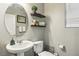Well-lit half bathroom features pedestal sink, floating shelves, and modern fixtures at 334 E Neal Ave, Las Vegas, NV 89183