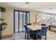 Dining area featuring a marble table, blue chairs, tile flooring, and natural light from the sliding door and windows at 334 E Neal Ave, Las Vegas, NV 89183
