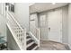 Bright entryway with a staircase featuring white railings, dark wood steps, and stylish tile flooring at 334 E Neal Ave, Las Vegas, NV 89183