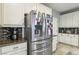 Kitchen close-up of stainless steel refrigerator, custom cabinets and tile backsplash at 334 E Neal Ave, Las Vegas, NV 89183