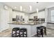 Kitchen featuring an island with granite countertops, white cabinets, stainless steel appliances, and modern pendant lighting at 334 E Neal Ave, Las Vegas, NV 89183