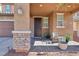 Welcoming front porch featuring stone pillars, a cozy seating area, and a stylish front door at 334 E Neal Ave, Las Vegas, NV 89183