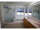 Bright, spacious bathroom featuring tile floors, double sinks with wood cabinets, a glass shower, and a soaking tub at 3440 Crystal Tower St, Las Vegas, NV 89129