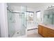 A sleek, glass-enclosed shower complements the soaking tub and oak vanity in this brightly lit bathroom at 3440 Crystal Tower St, Las Vegas, NV 89129
