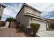 Two-story home featuring desert landscaping, a two-car garage, and a tile roof under a cloudy blue sky at 3440 Crystal Tower St, Las Vegas, NV 89129