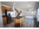 Kitchen flows to living area with wood cabinets, stainless steel appliances, granite counters, and tile floors at 3440 Crystal Tower St, Las Vegas, NV 89129
