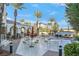 Inviting outdoor patio with tables, chairs, and umbrellas amidst lush landscaping, perfect for relaxation and socializing at 3440 Crystal Tower St, Las Vegas, NV 89129
