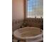 Relaxing bathtub with tile surround and a bright window for natural light at 3551 Sagebrush Ave, Pahrump, NV 89048