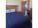 Cozy bedroom featuring a comfortable bed with a blue comforter and natural lighting at 3551 Sagebrush Ave, Pahrump, NV 89048