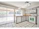 Galley kitchen features gray cabinets, white appliances, and tile flooring at 3596 Bronco Rd, Las Vegas, NV 89103