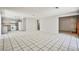 Open-concept living room and kitchen area with gray cabinets, appliances, and large tile flooring at 3596 Bronco Rd, Las Vegas, NV 89103