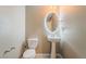 Compact half bathroom features modern round mirror with LED lighting, pedestal sink, and tiled flooring at 3855 Park Field Dr, Las Vegas, NV 89120