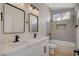 Modern bathroom features a double vanity with black faucets and a tiled shower-tub combo at 4010 Herblinda Ln, North Las Vegas, NV 89032
