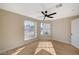 Sunny bedroom with new floors, ceiling fan, and two windows showing a view of the neighborhood at 4010 Herblinda Ln, North Las Vegas, NV 89032