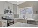 Modern kitchen with stainless appliances, bright white countertops and cabinets with contemporary fixtures and finishes at 4010 Herblinda Ln, North Las Vegas, NV 89032