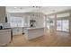 Well-lit kitchen with white cabinets, stainless appliances, an island, and sliding glass doors with wood floors at 4010 Herblinda Ln, North Las Vegas, NV 89032