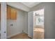 Bright laundry room with storage cabinets and closet near a bedroom that has a ceiling fan at 4010 Herblinda Ln, North Las Vegas, NV 89032