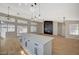 Open floor plan with kitchen island, wood flooring, pendant lighting, and windows bringing in natural light at 4010 Herblinda Ln, North Las Vegas, NV 89032
