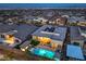 Wide aerial view of home with a sparkling pool, backyard putting green, and cozy outdoor lounge area at twilight at 461 Highview Ridge Ave, Las Vegas, NV 89138