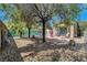 Spacious backyard with a mix of patio, gravel, and mature trees offering a versatile outdoor living area at 4802 Regalo Bello St, Las Vegas, NV 89135