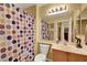 A full bathroom featuring a shower with colorful curtain, vanity with sink and generous mirror at 4802 Regalo Bello St, Las Vegas, NV 89135